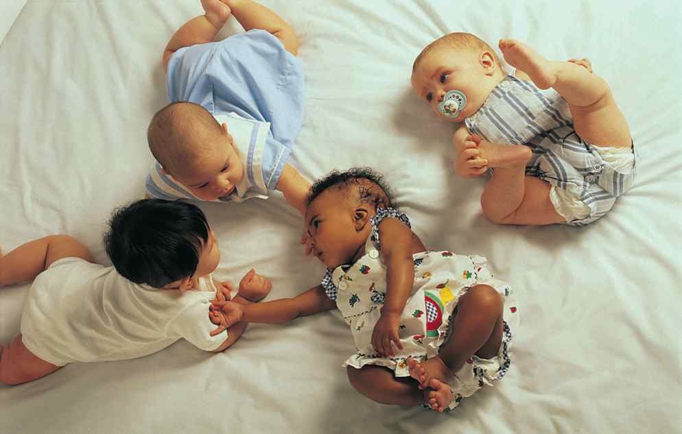 Multi-cultural babies on bed