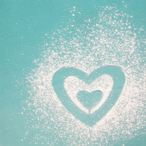 Image of two hearts outlined within each other made from powder against a blue backdrop.