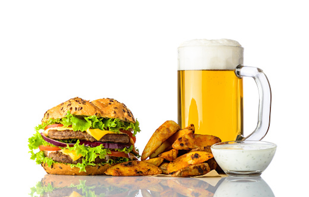 Image of a burger, fries, beer, and sauce.