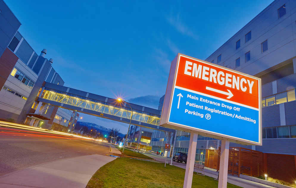 Emergency sign against hospital background.