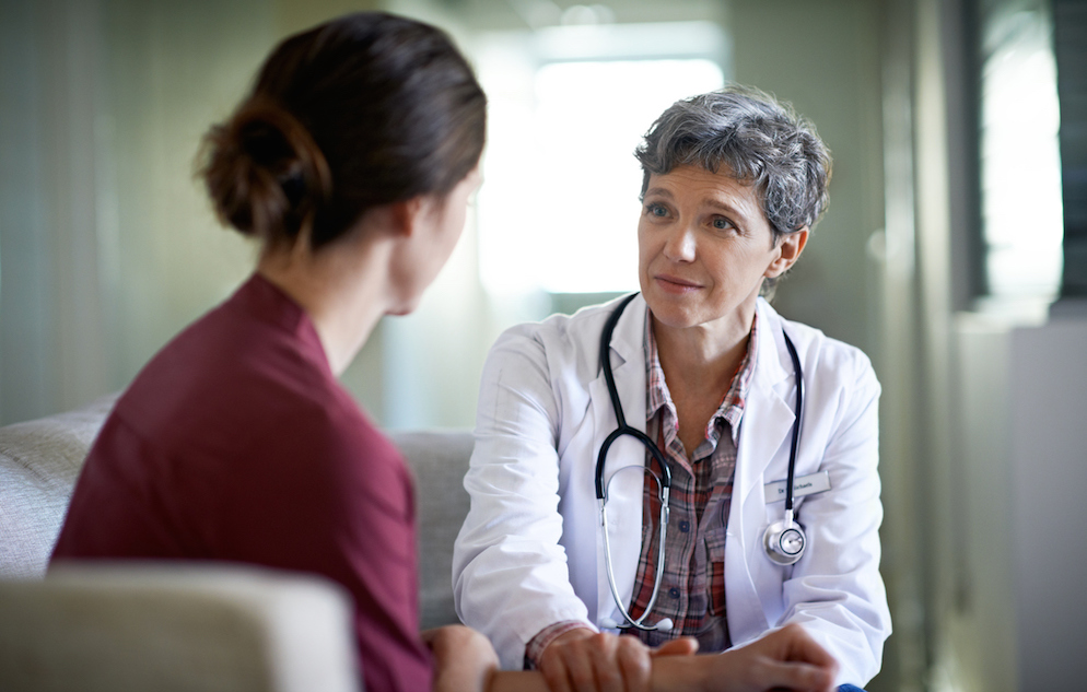 Shot of a compassionate doctor comforting a young woman in a hospital waiting room