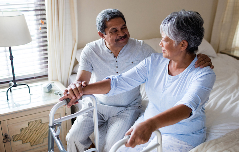 Elderly couple sitting on bed