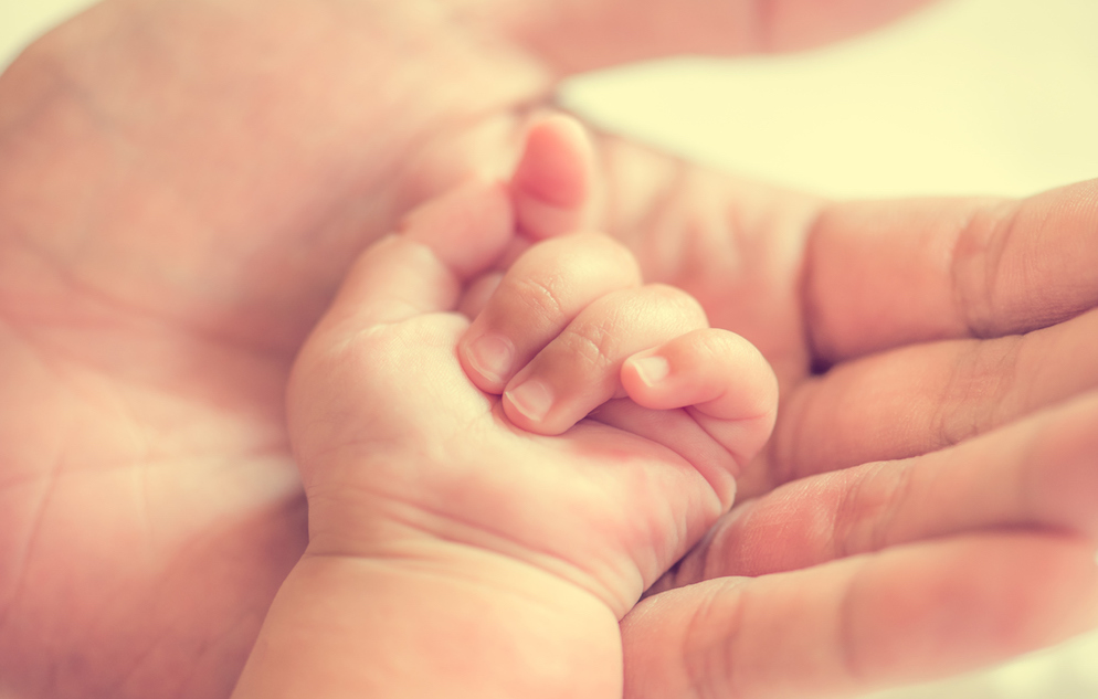 father holding baby hand