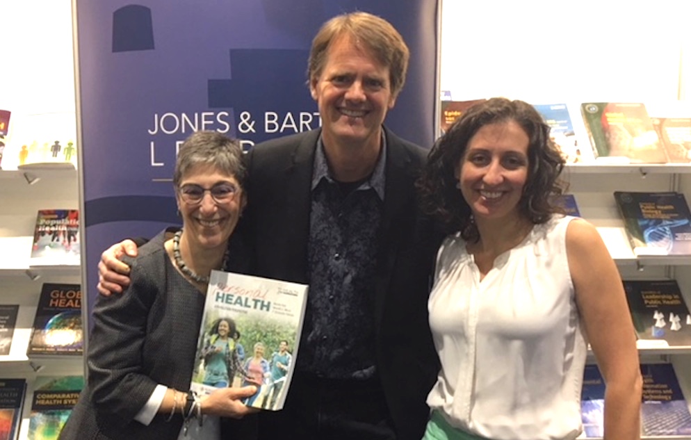 From left to right: Dean of Research Michele Kiely, Professor Chris Palmedo, and Professor Meredith Manze showcase their newly published textbook "Personal Health: A Population Perspective", which seeks to engage students in understanding relevant personal health issues within a broader population health framework.