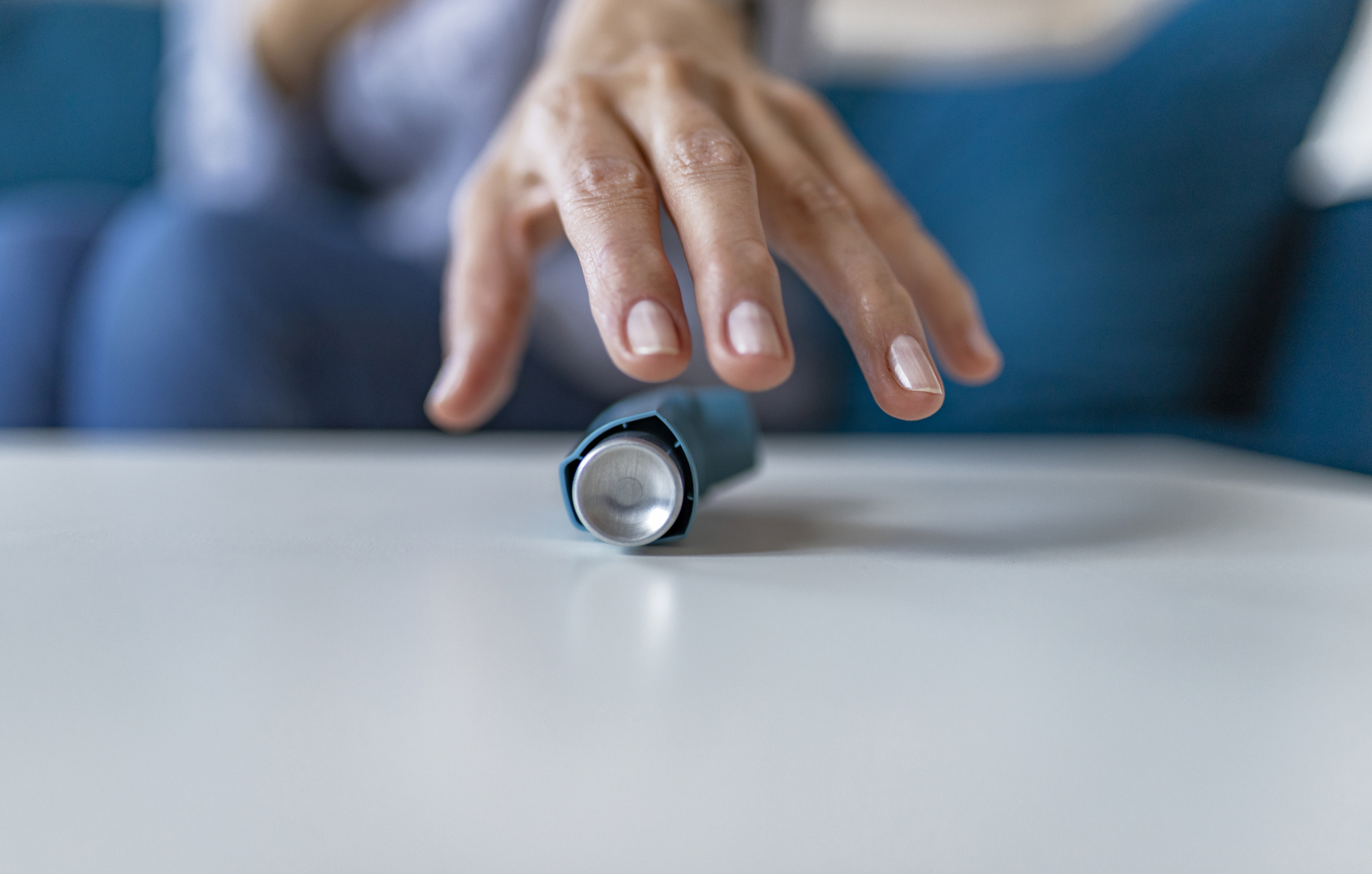 woman reaching for asthma inhaler