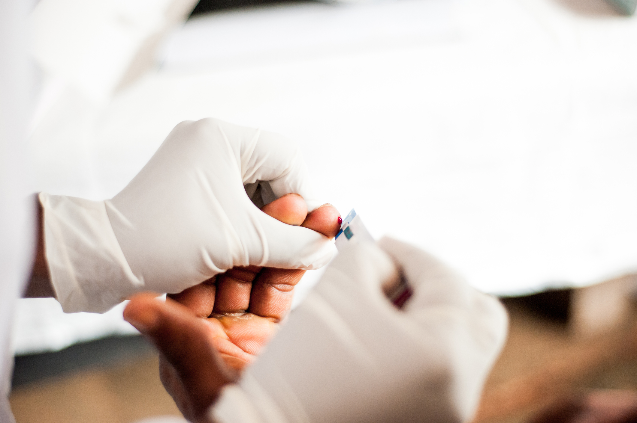 health worker performing HIV test on person