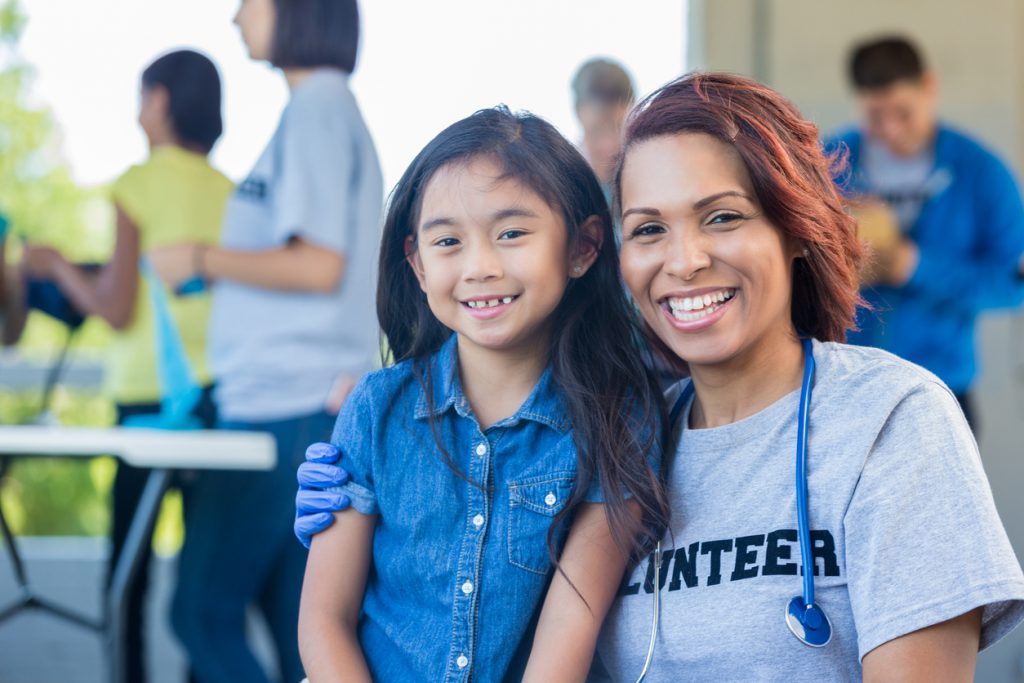 Volunteer doctor and child at community health fair