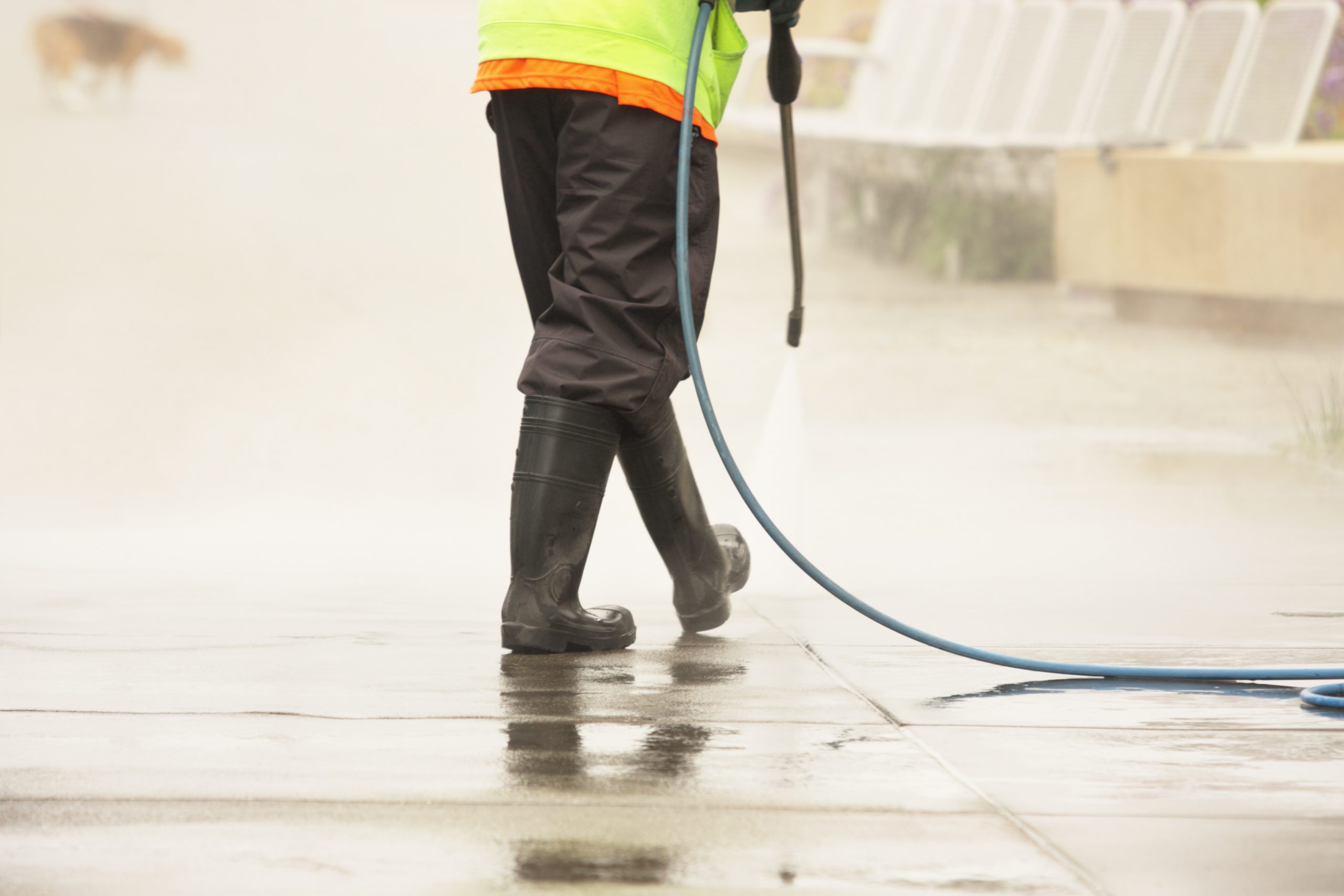 city worker steam cleans sidewalk