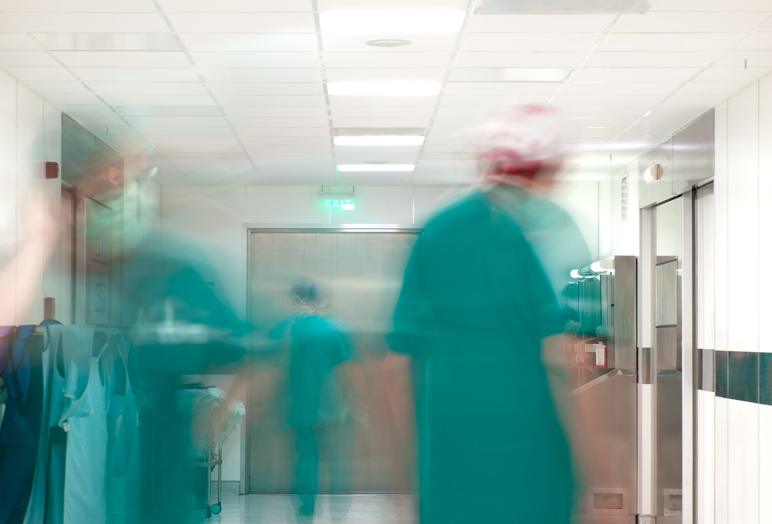 Blurred figures of doctors with medical uniforms in hospital