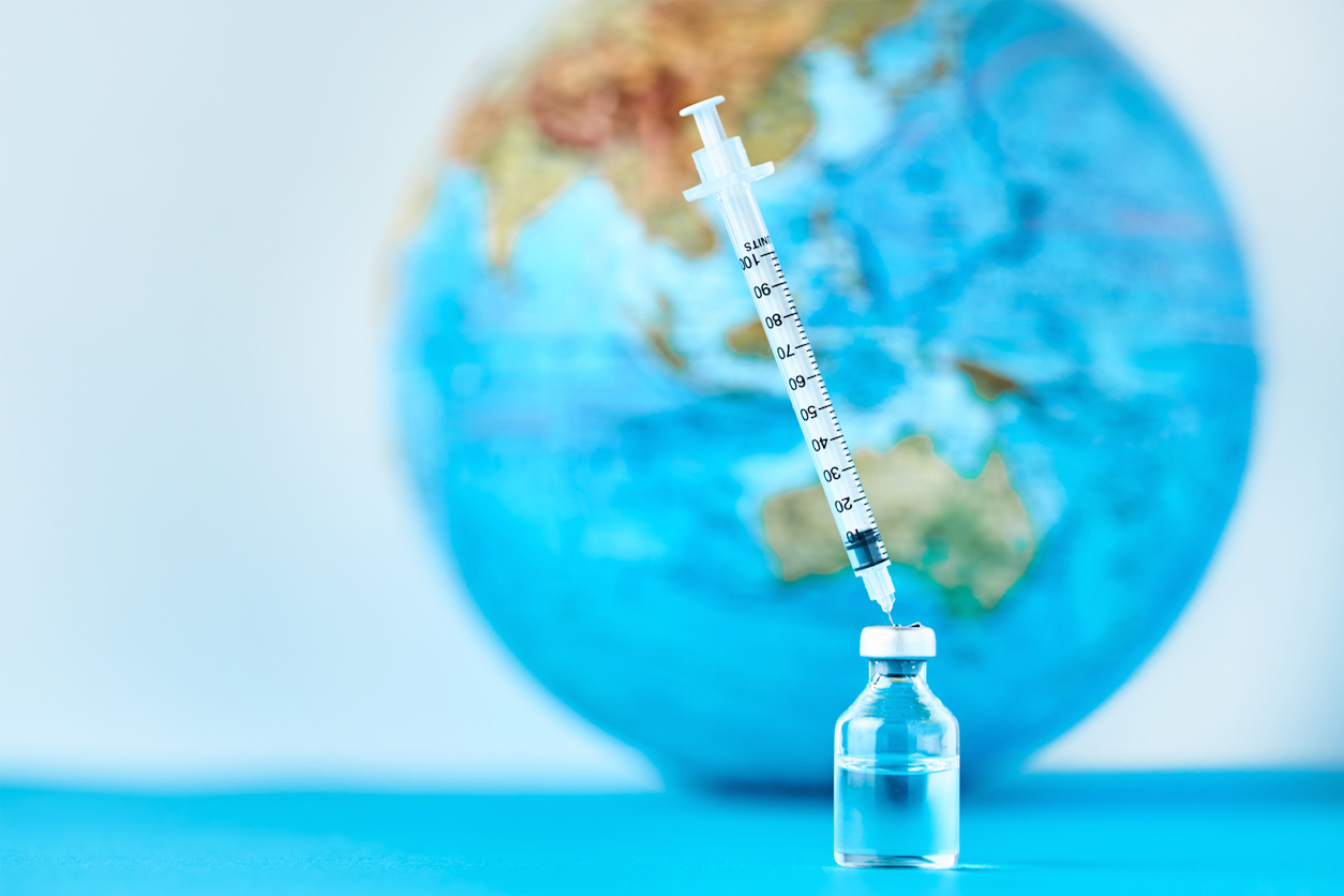 vaccine vial in front of globe