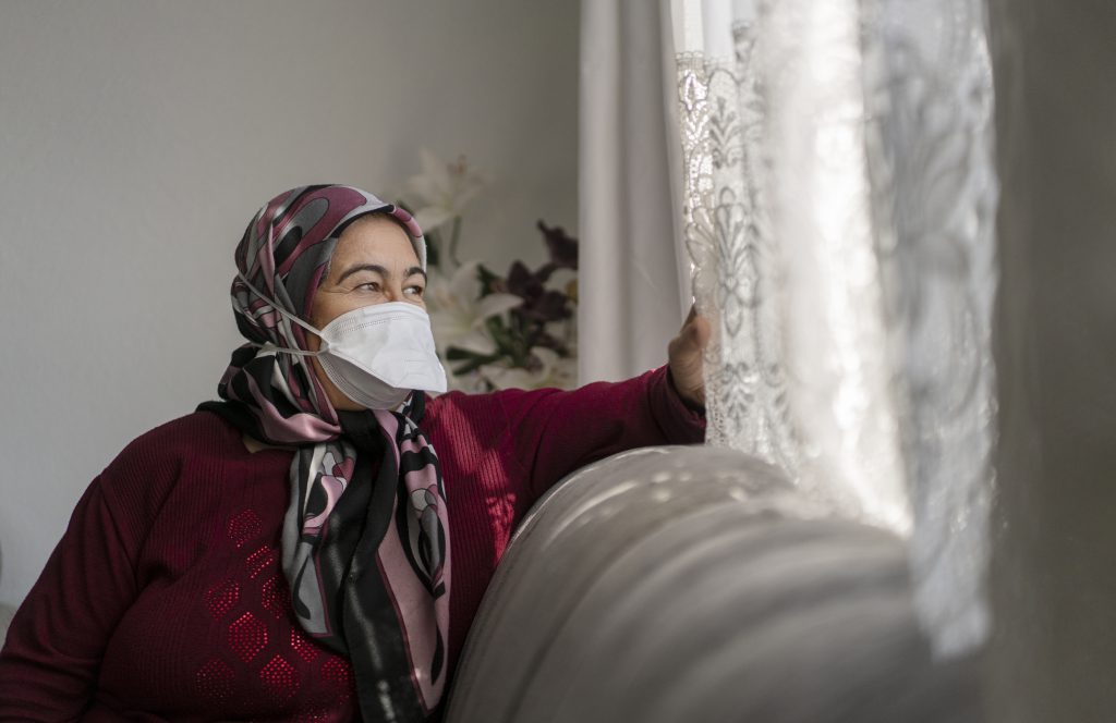 Elderly woman quarantining at home with face mask on