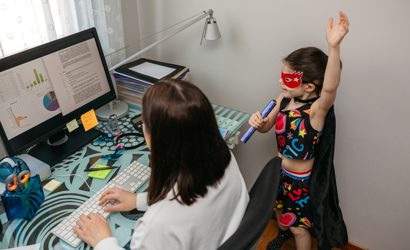 Woman working from home with her daughter singing by her side