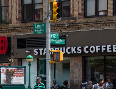 125th st and lenox street signs with starbucks sign in background