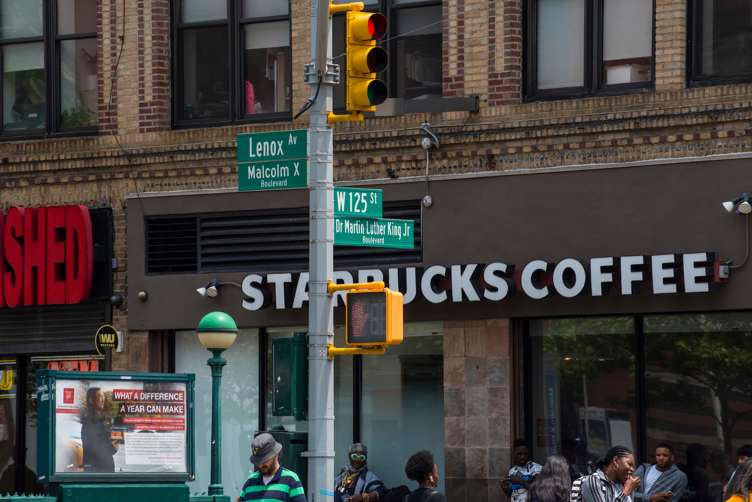 125th st and lenox street signs with starbucks sign in background