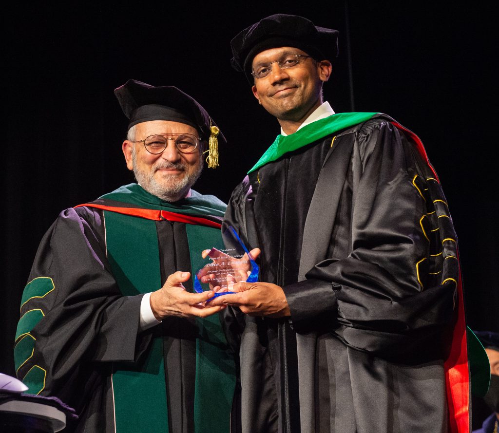 Dr. Dave A. Chokshi accepts the Champion of Public Health Award from Dean Ayman El-Mohandes