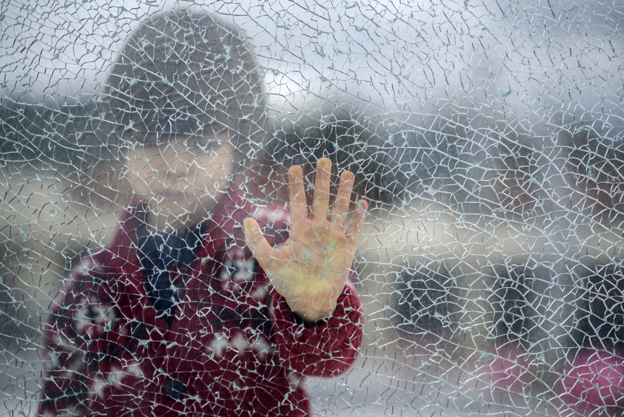 child behind broken glass
