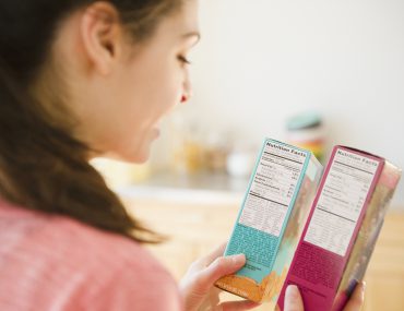 Woman reading nutrition facts on food packaging