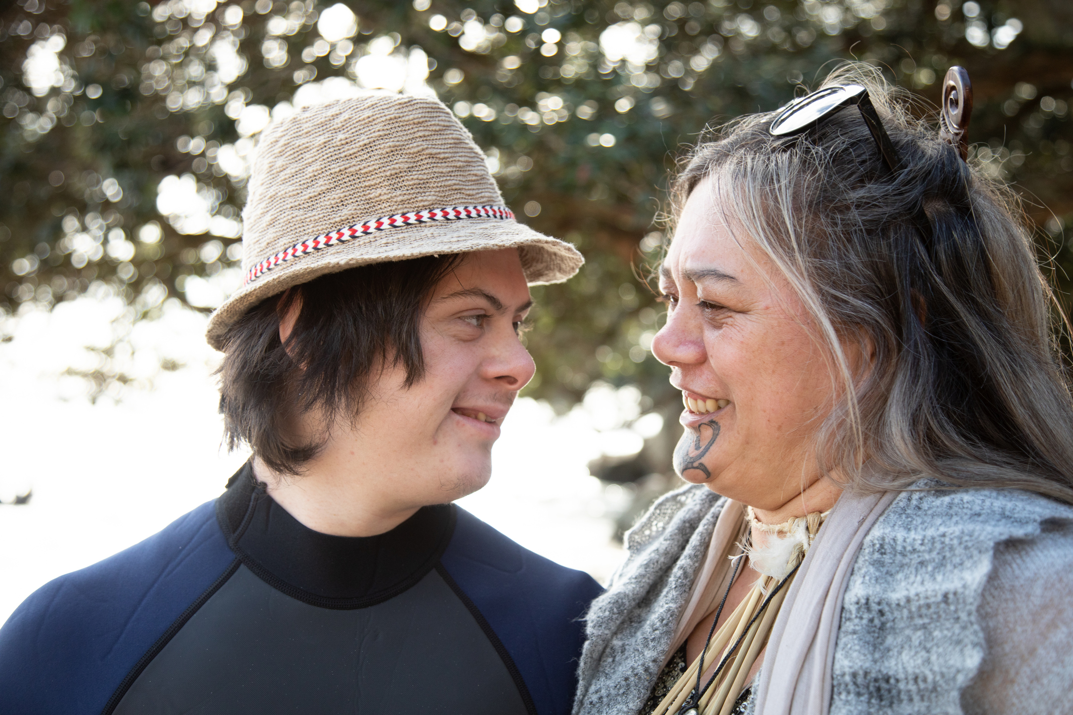 A young man with down syndrome and his mother together on the beach