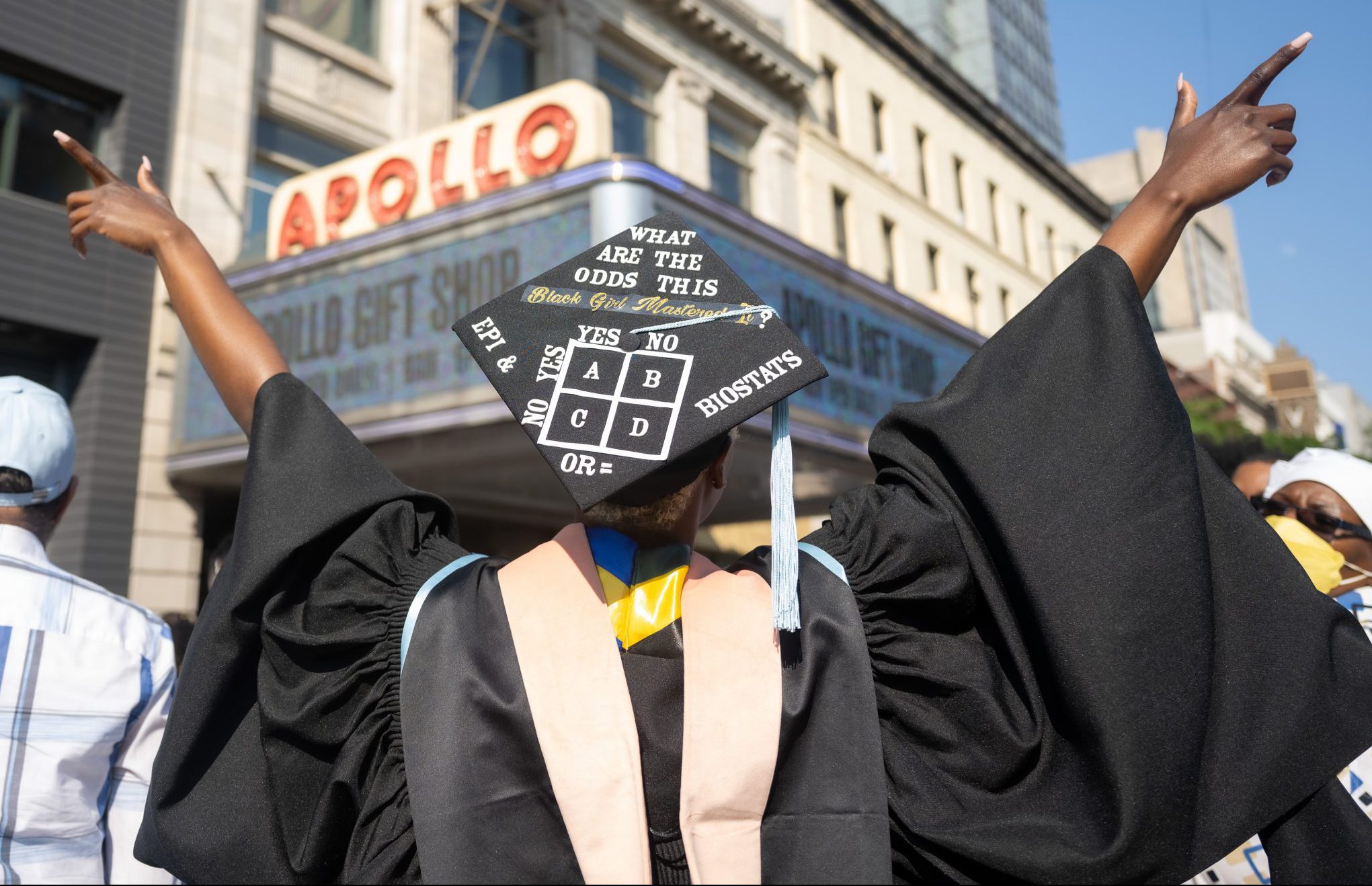Graduate in front of Apollo marquee
