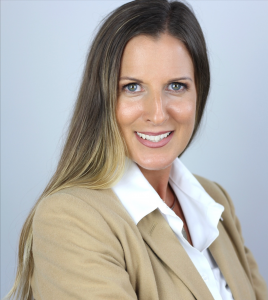 person with long hair, tan blazer and arms crossed poses for headshot