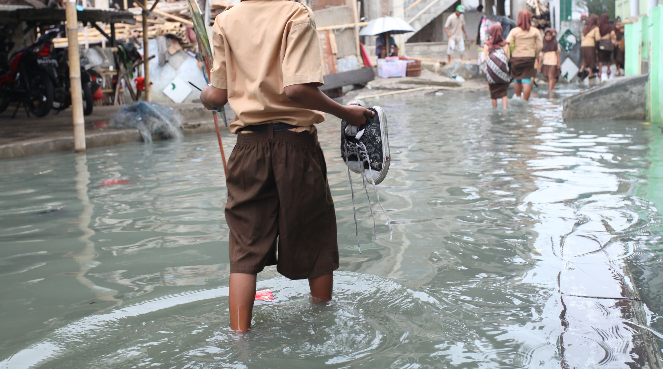 people wading in flood waters