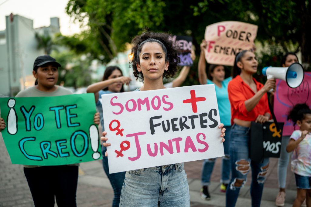 Women protesting with signs in Spanish