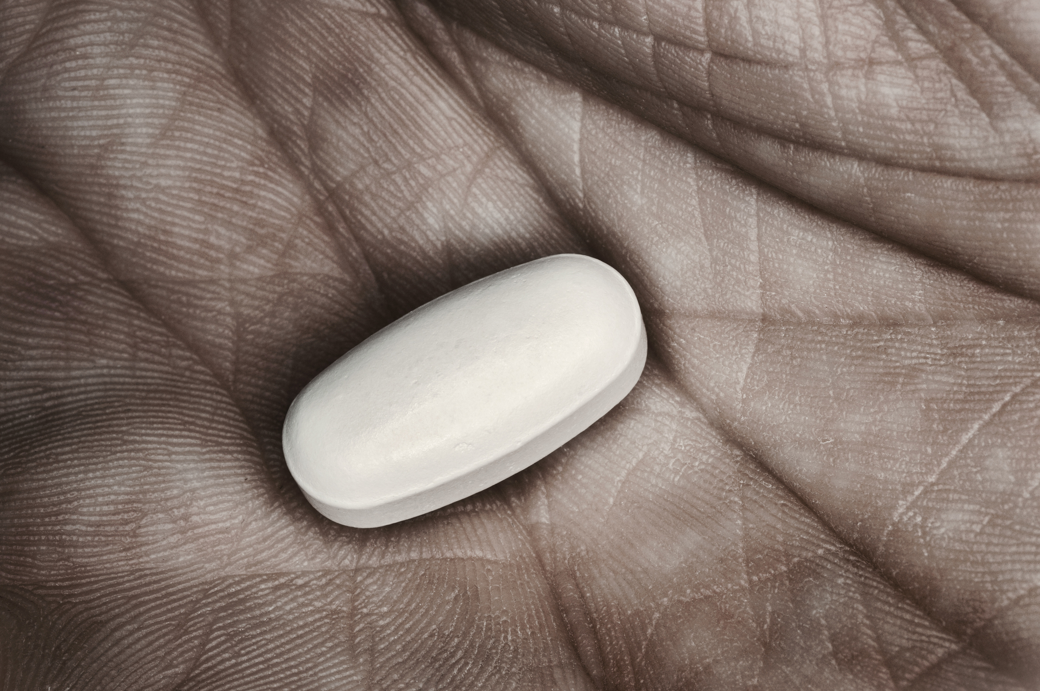 close-up of pill in man's hand