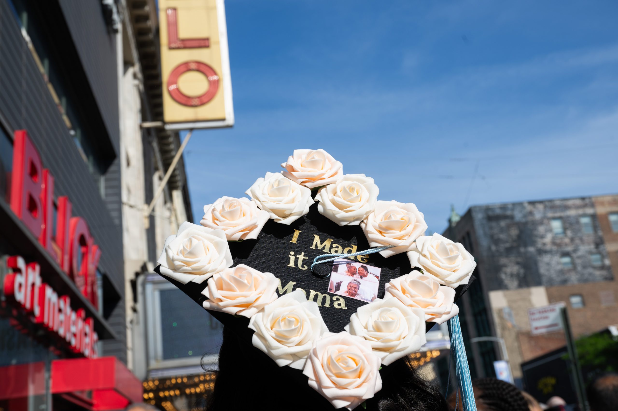 graduate with decorated cap that says "Mama I made it"