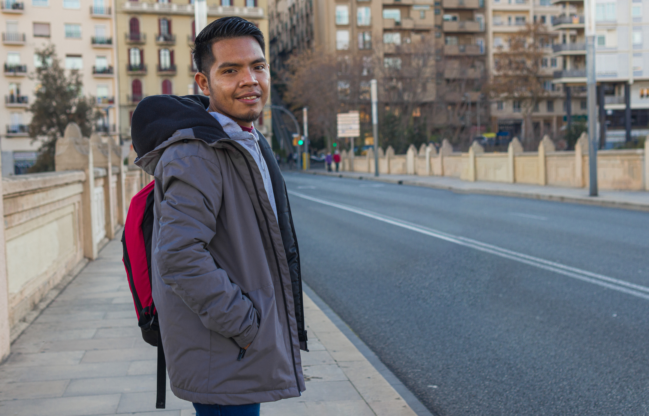 Latin American man standing on sidewalk in Spain