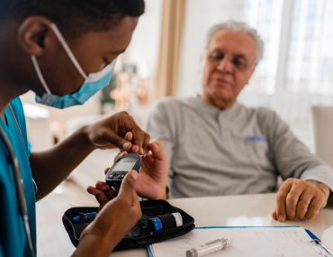 health worker tests patient's blood sugar