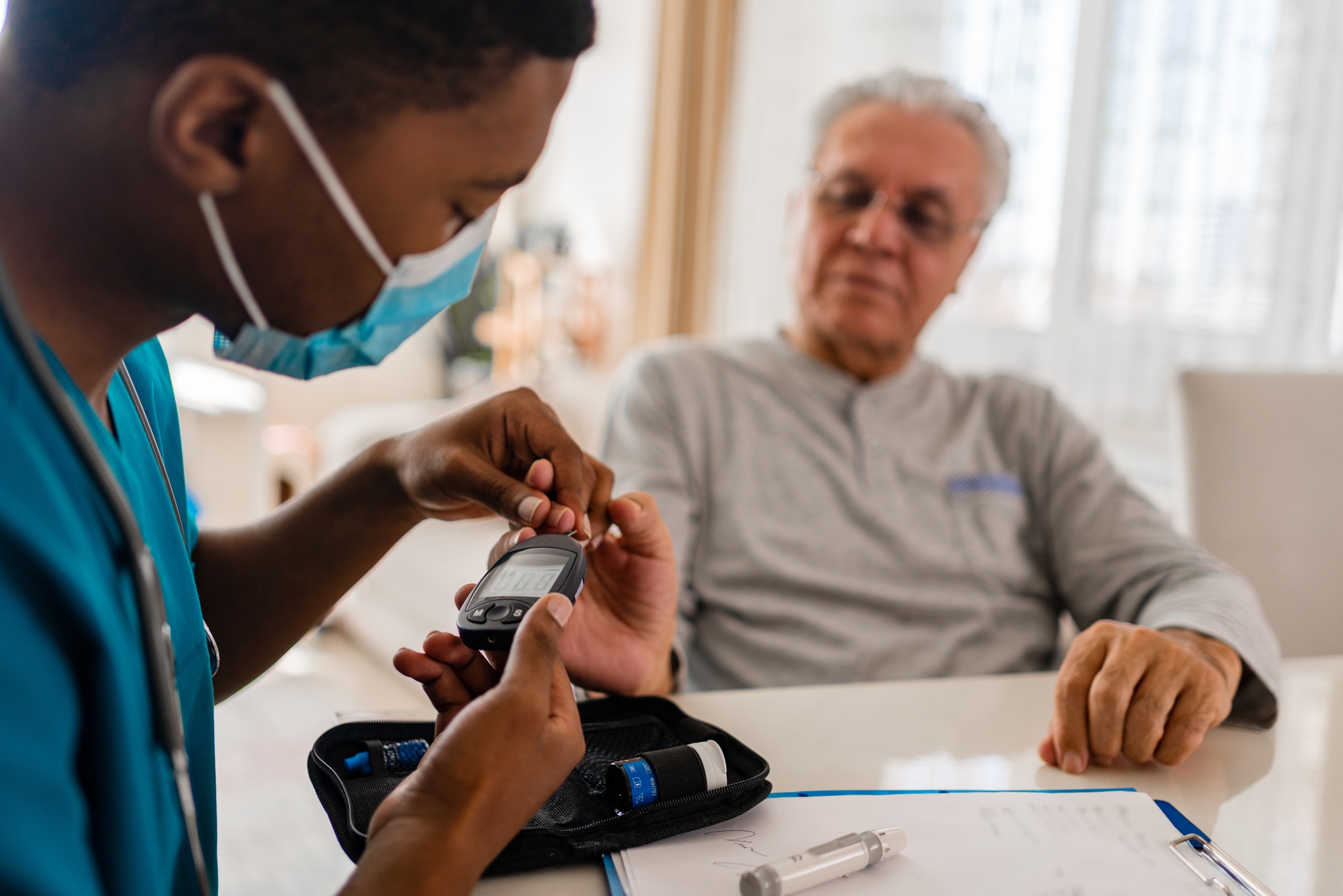 health worker tests patient's blood sugar