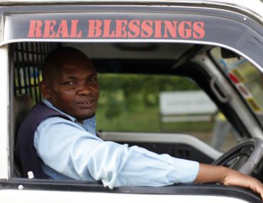 Kenyan truck driver looks out truck window