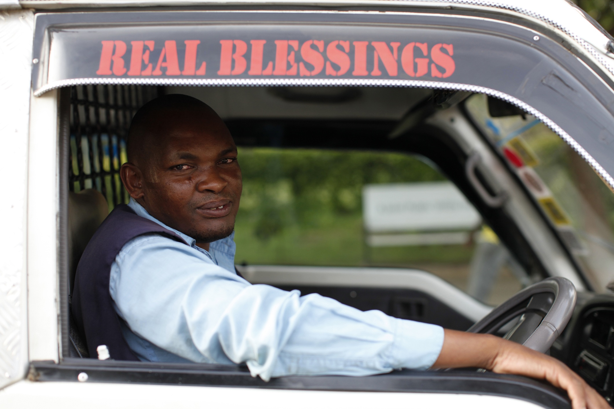 Kenyan truck driver looks out truck window