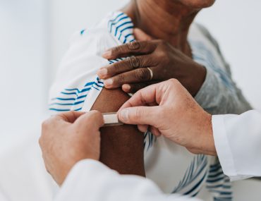 health worker applies band-aid after vaccine