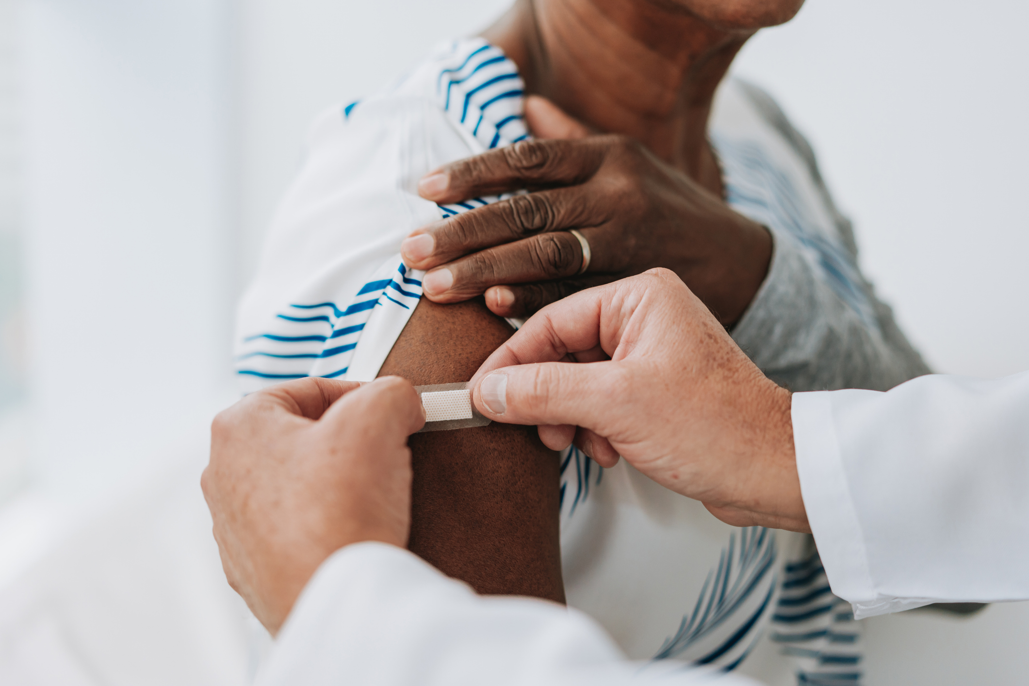 health worker applies band-aid after vaccine