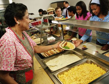 cafeteria worker serving lunch to students