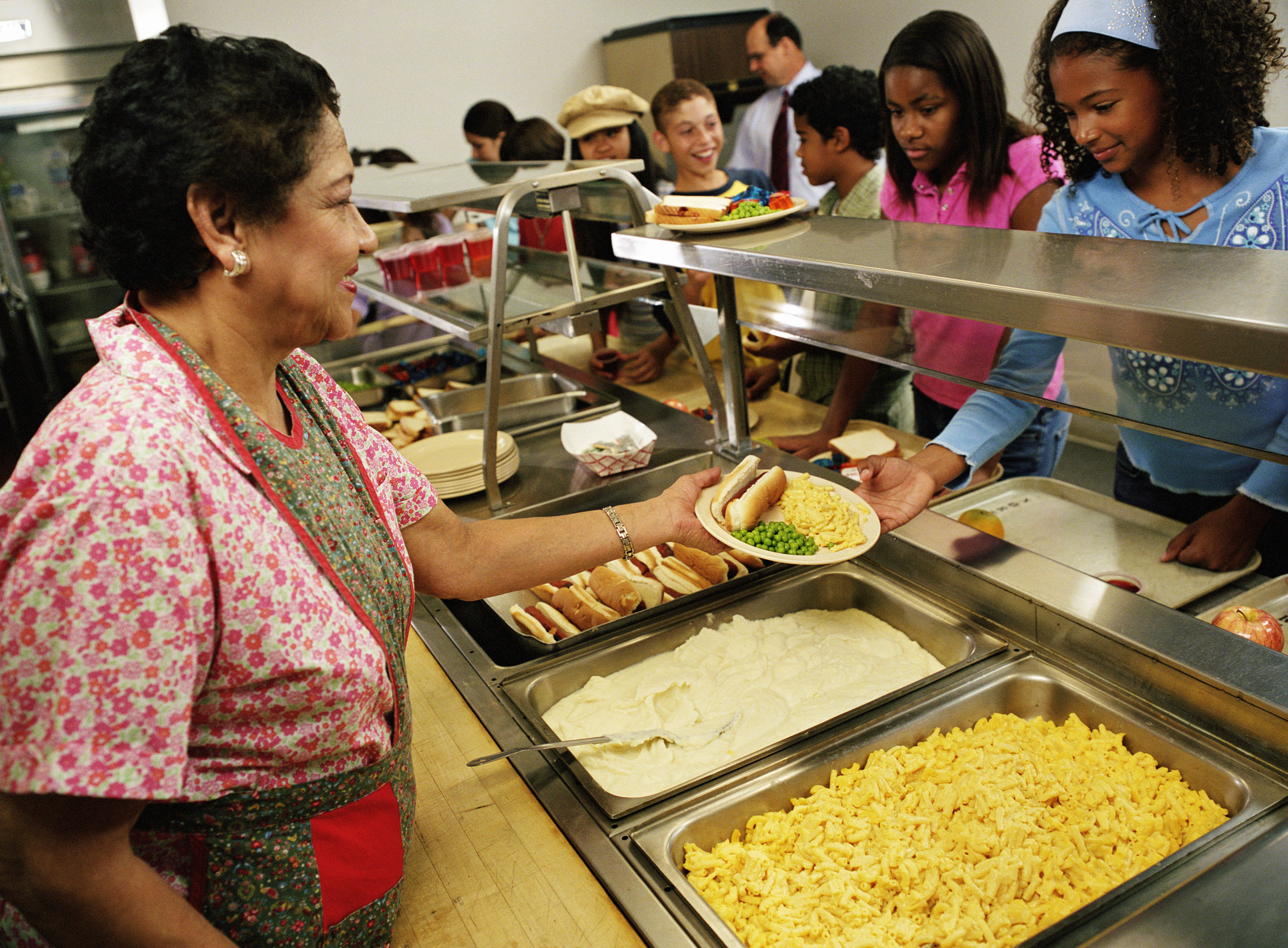 cafeteria worker serving lunch to students