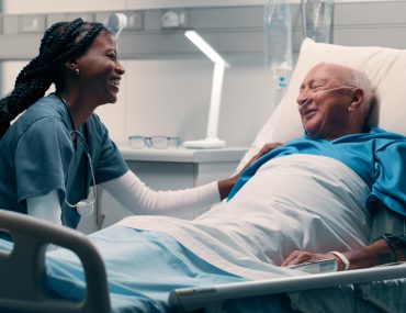 nurse cares for elderly man in hospital