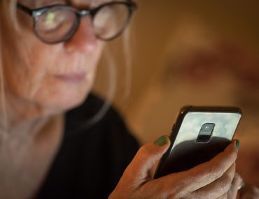 older woman looks at smartphone
