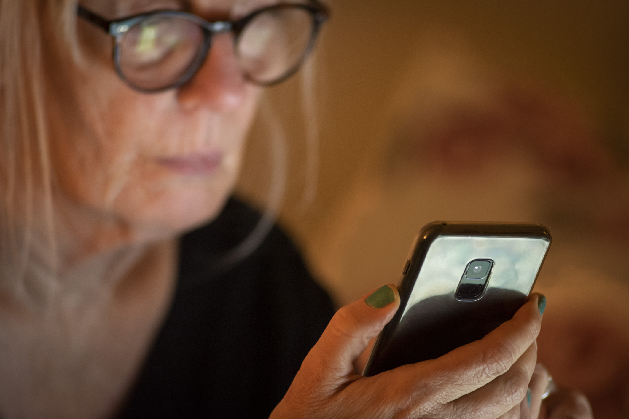 older woman looks at smartphone