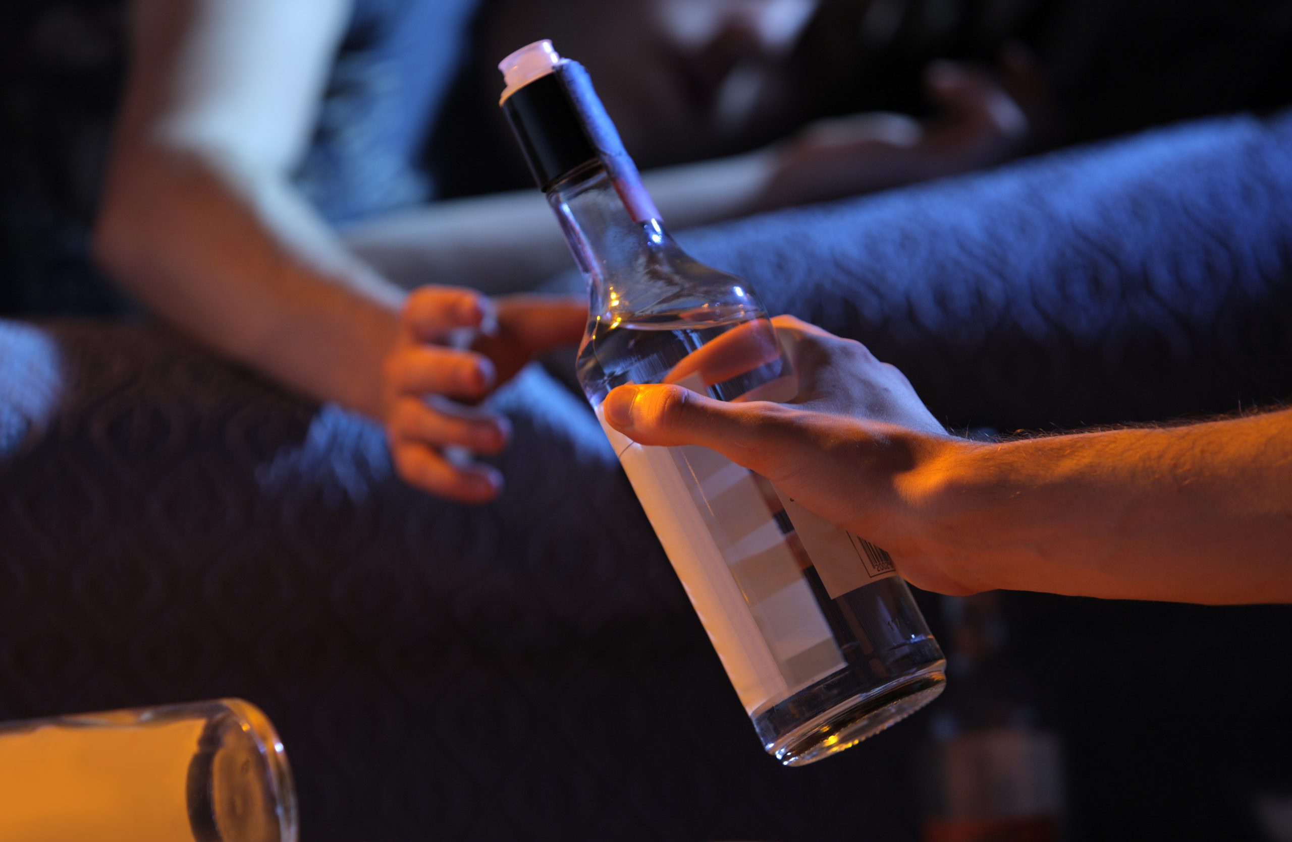 teens passing liquor bottle